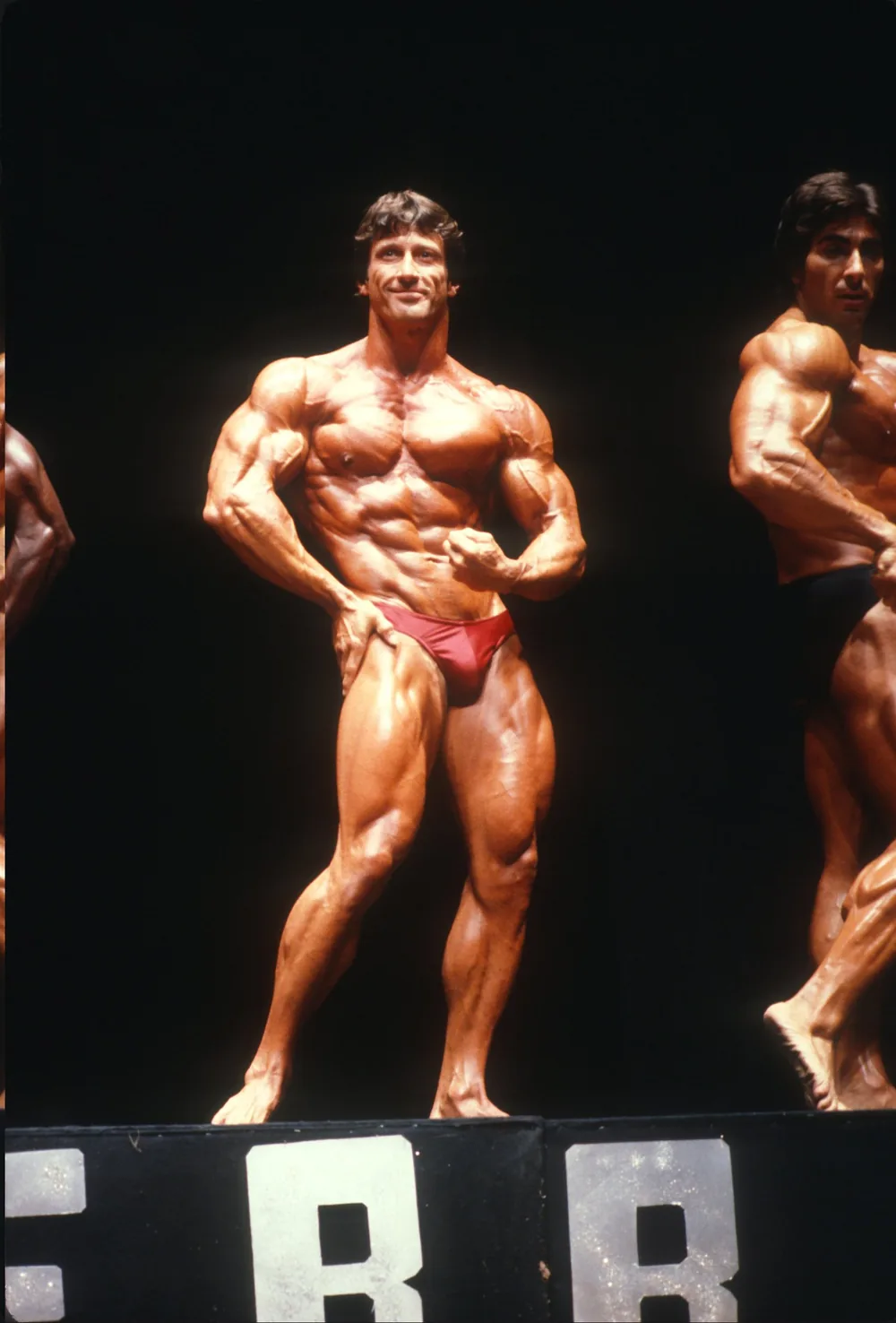 Frank Zane in a front double-biceps pose on the competition stage.