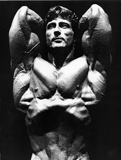 Frank Zane in a dramatic crossed-arms studio pose.