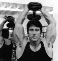 Frank Zane performing an overhead dumbbell triceps extension.