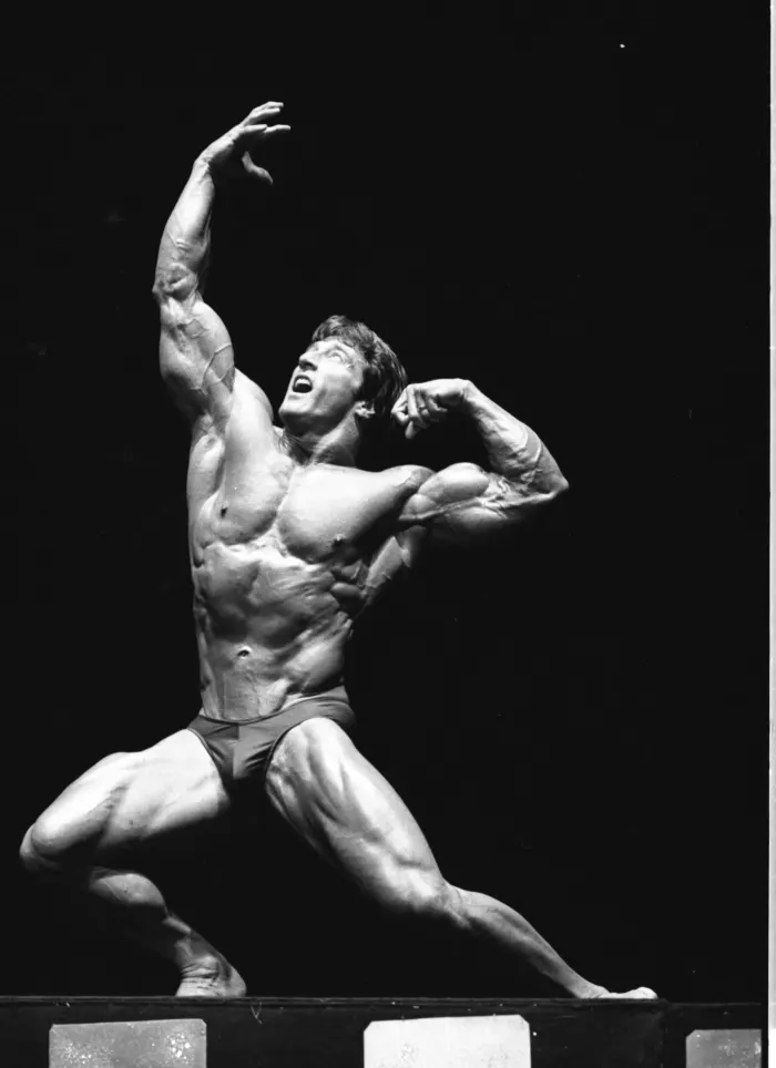 Peak on-stage intensity: a lunging pose, mouth open, arm thrust skyward.
